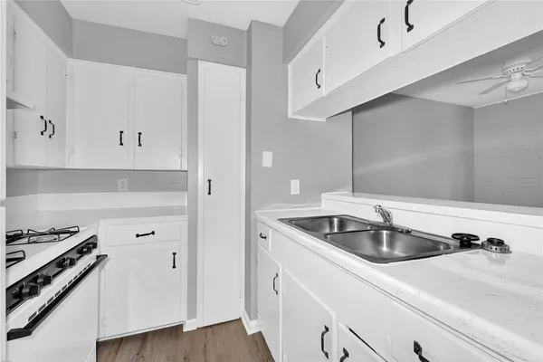a kitchen with a sink and wooden floor