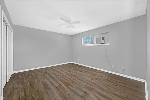 a view of an empty room with wooden floor