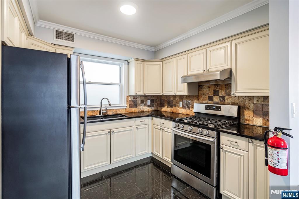 312 Vine Street Elizabeth, NJ 07202 - Photo 2 of 10 a kitchen with a sink stove top oven and cabinets