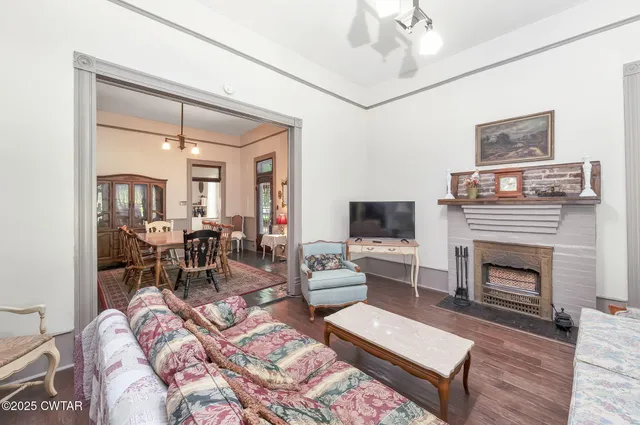a living room with furniture a fireplace and a flat screen tv