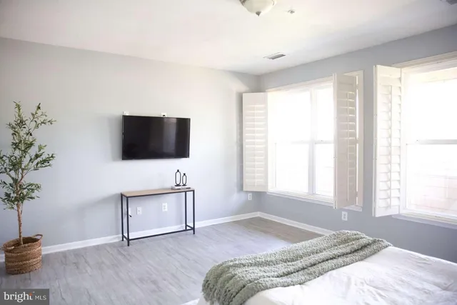 a spacious bedroom with a bed and a flat screen tv
