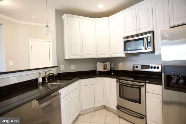 a kitchen with granite countertop white cabinets and black appliances