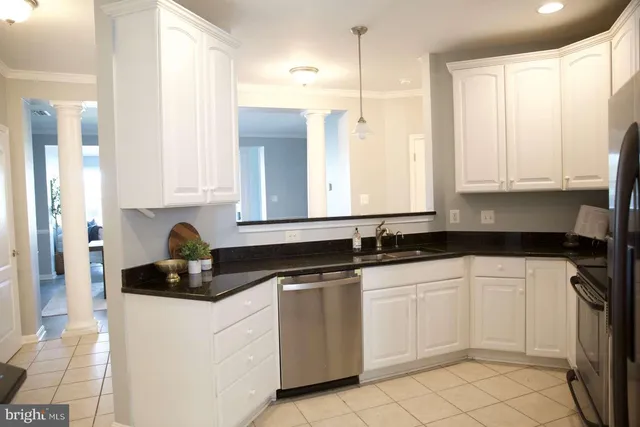 a kitchen with white cabinets and sink