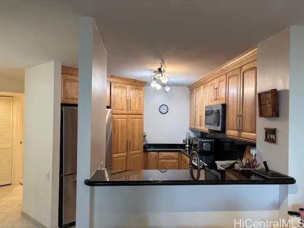 a view of a hallway with granite countertop a sink and cabinets