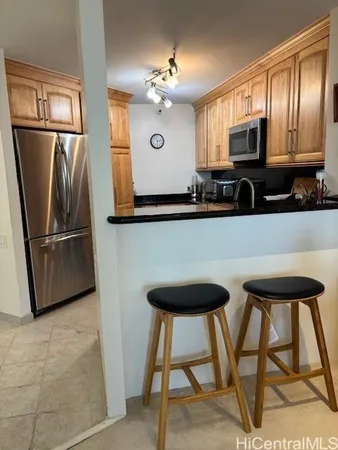 a kitchen with stainless steel appliances granite countertop a refrigerator a stove top oven and a sink with granite countertops