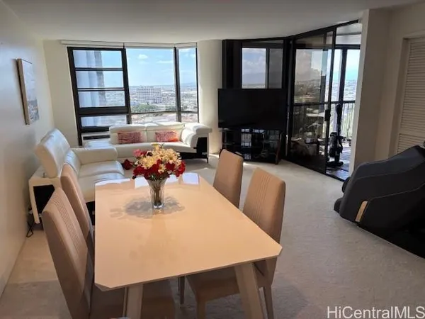 a dining room with furniture a window and a flat screen tv