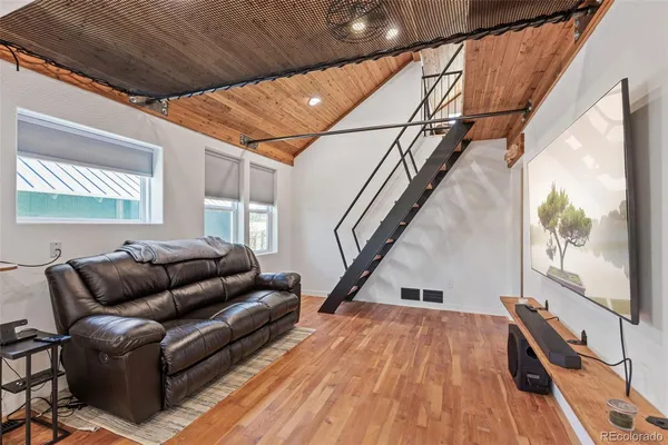 a living room with furniture and a wooden floor