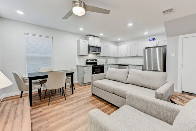 a living room kitchen with furniture and a wooden floor