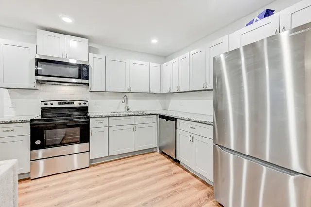 a kitchen with stainless steel appliances granite countertop a refrigerator sink and microwave