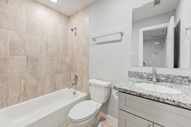 a bathroom with a granite countertop toilet a sink and bathtub
