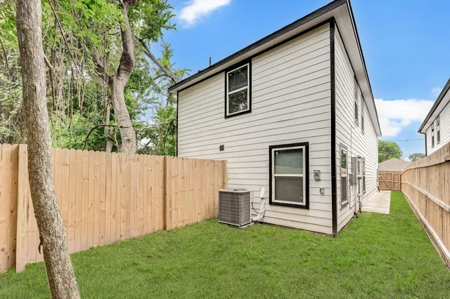 a view of a house with a yard and wooden fence