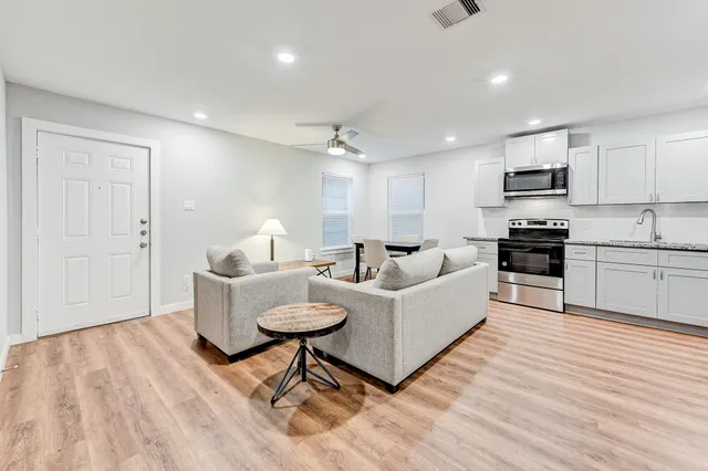 a living room with furniture and a wooden floor