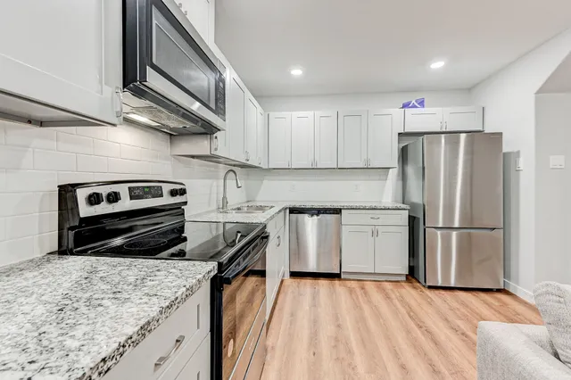 a kitchen with a refrigerator sink and stove