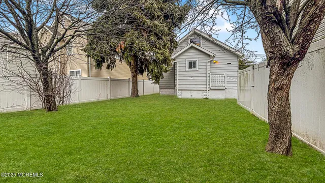 a front view of a house with a garden and trees