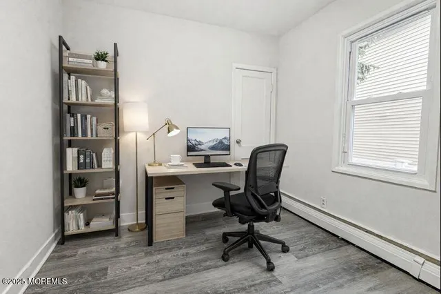 a view of a workspace with furniture and a window