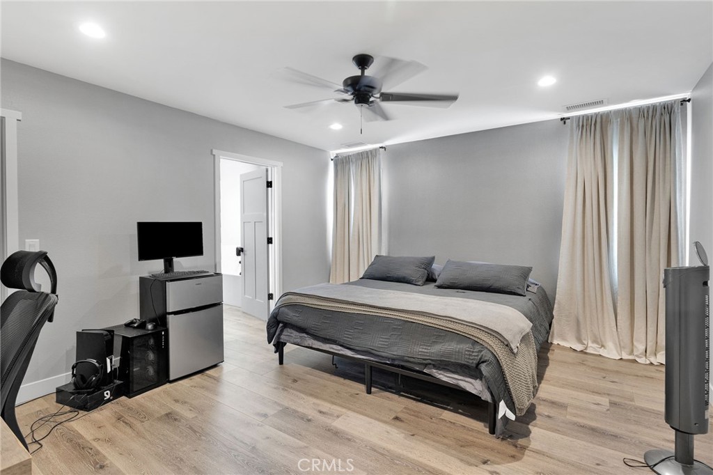 21533 Del Oro Road Apple Valley, CA 92308 - Photo 13 of 35 a bedroom with a bed and a chandelier