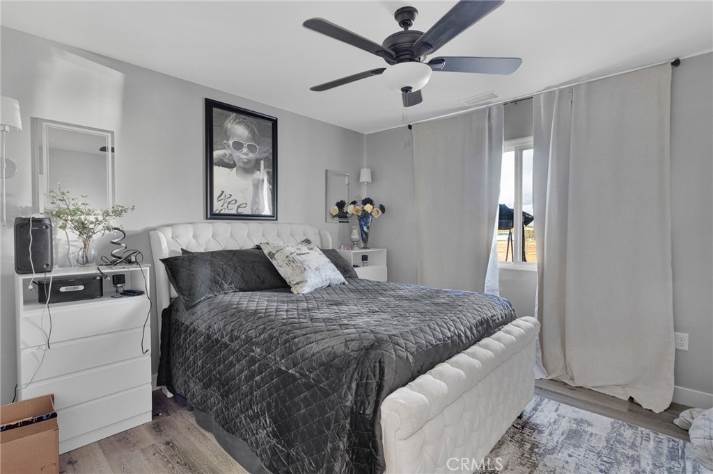 21533 Del Oro Road Apple Valley, CA 92308 - Photo 21 of 35 a bedroom with a large bed and a chandelier