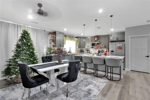 a kitchen with kitchen island granite countertop a dining table chairs and white cabinets