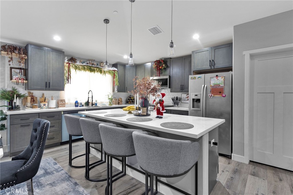 21533 Del Oro Road Apple Valley, CA 92308 - Photo 9 of 35 a kitchen with stainless steel appliances granite countertop a sink a stove a refrigerator cabinets and chairs