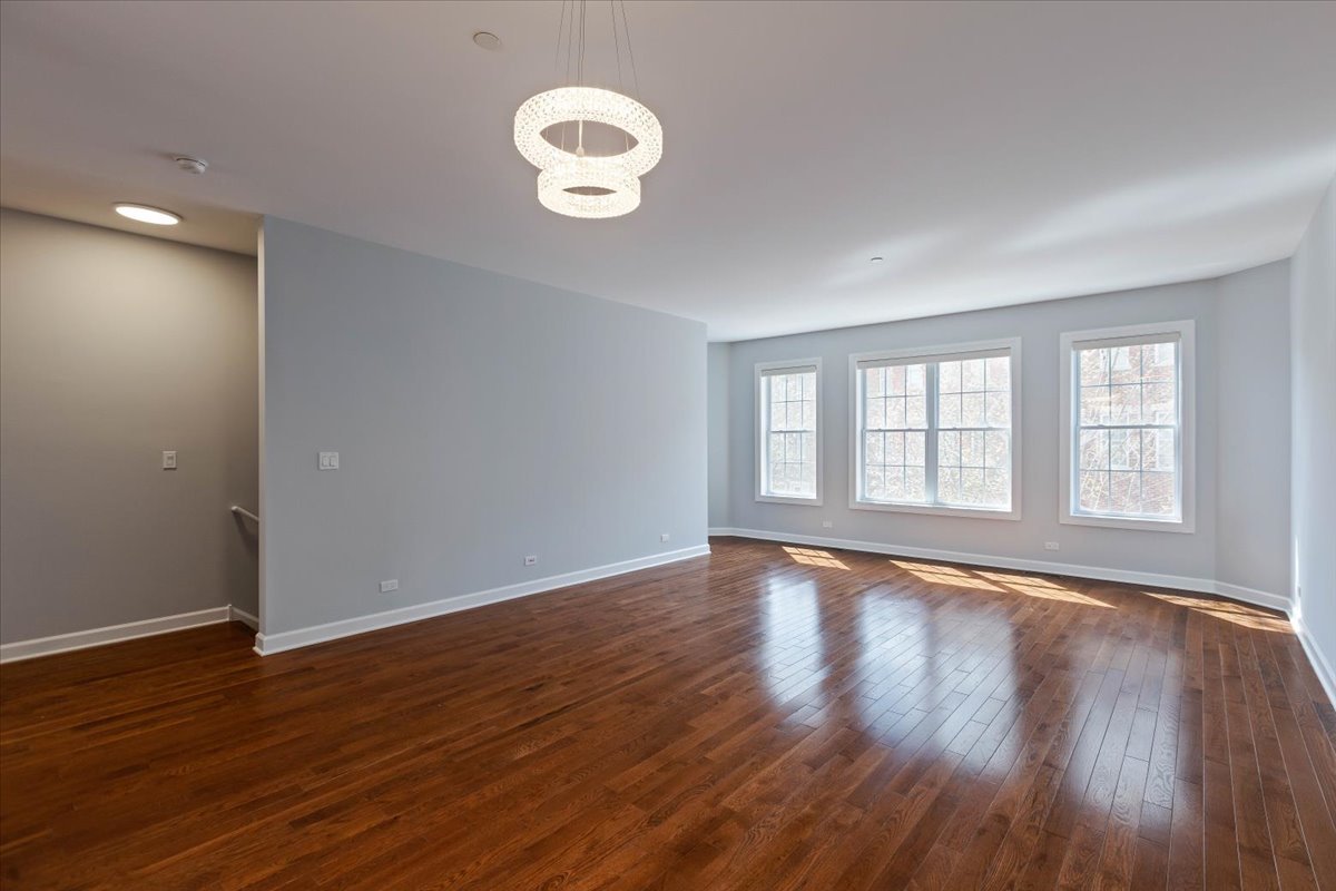 1669 Church Street Evanston, IL 60201 - Photo 5 of 31 a view of an empty room with wooden floor and a window