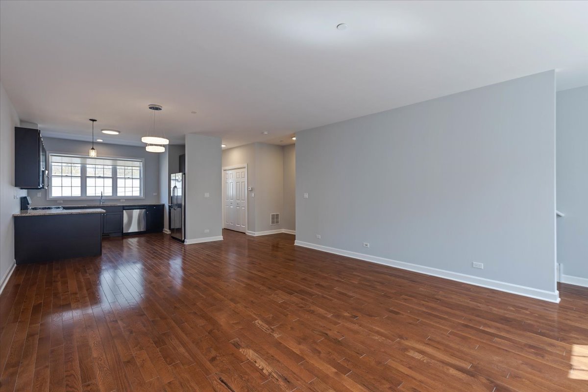 1669 Church Street Evanston, IL 60201 - Photo 6 of 31 a view of a big room with wooden floor and a kitchen