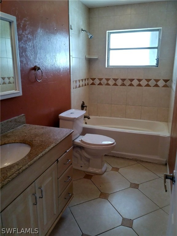 1003 East Penn Road Lehigh Acres, FL 33936 - Photo 12 of 12 a bathroom with a granite countertop sink a toilet a mirror and bathtub