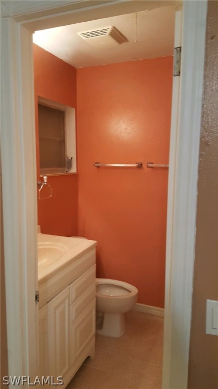 1003 East Penn Road Lehigh Acres, FL 33936 - Photo 6 of 12 a bathroom with a toilet a sink and vanity