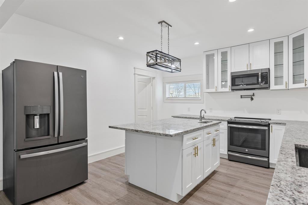 509 Maple Street Commerce, TX 75428 - Photo 12 of 36 a kitchen with stainless steel appliances granite countertop a stove a sink and a refrigerator