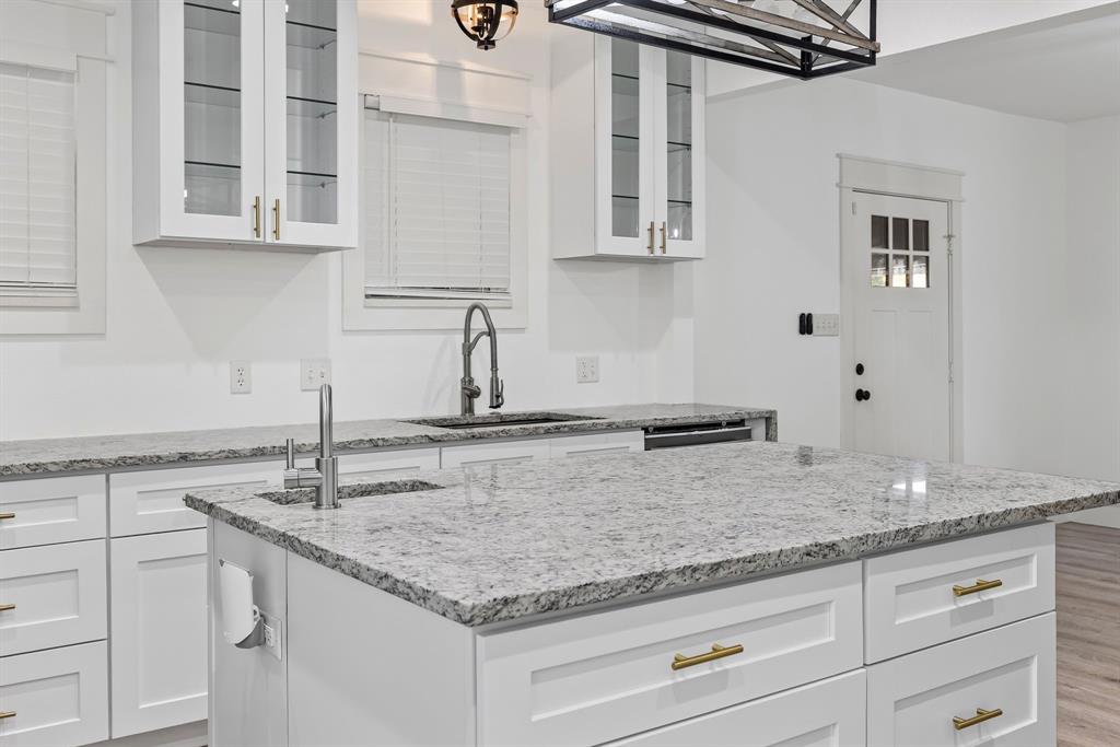 509 Maple Street Commerce, TX 75428 - Photo 13 of 36 a kitchen with stainless steel appliances granite countertop a sink and cabinets