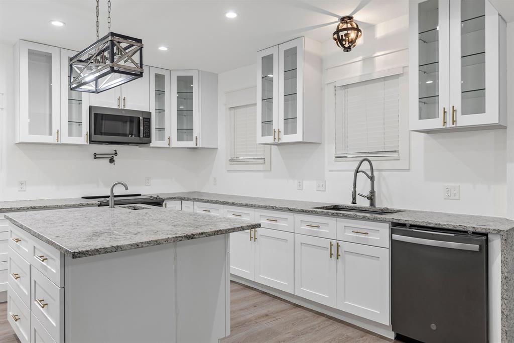 509 Maple Street Commerce, TX 75428 - Photo 15 of 36 a kitchen with granite countertop a sink cabinets and stainless steel appliances