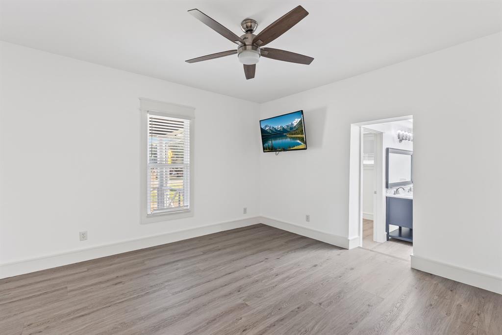 509 Maple Street Commerce, TX 75428 - Photo 18 of 36 an empty room with wooden floor and windows