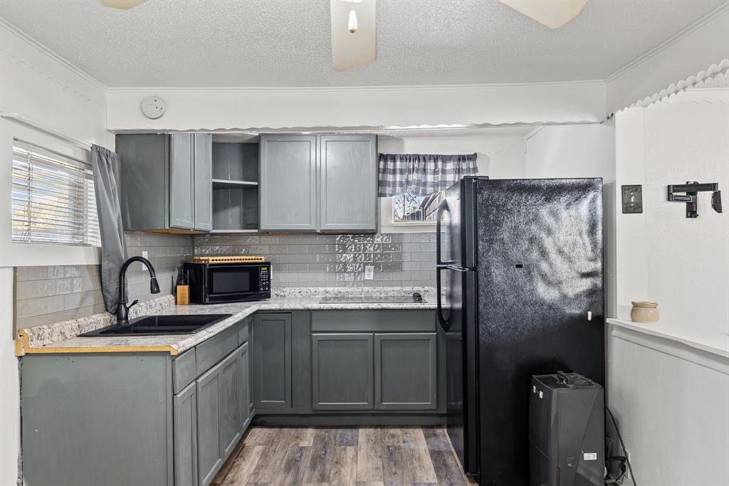 509 Maple Street Commerce, TX 75428 - Photo 29 of 36 a kitchen with a refrigerator sink and cabinets