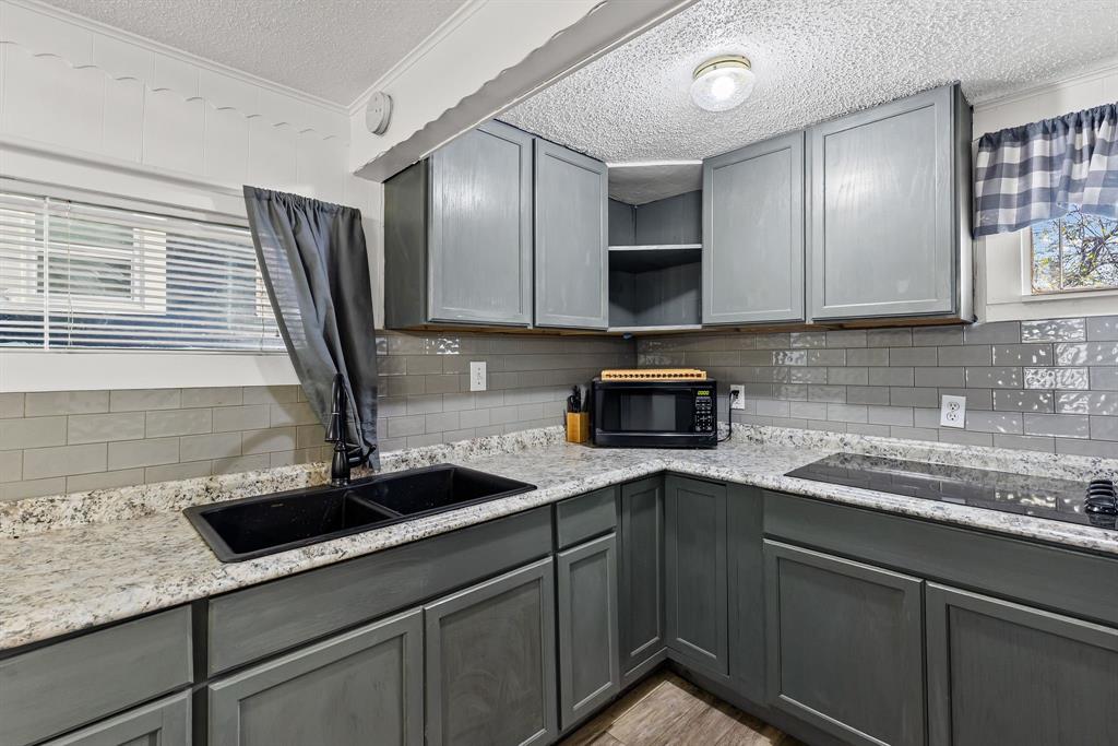 509 Maple Street Commerce, TX 75428 - Photo 30 of 36 a kitchen with stainless steel appliances granite countertop a sink and white cabinets