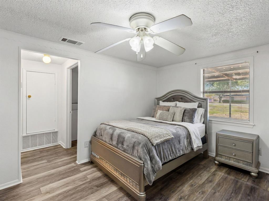 509 Maple Street Commerce, TX 75428 - Photo 31 of 36 a bedroom with a bed and wooden floor