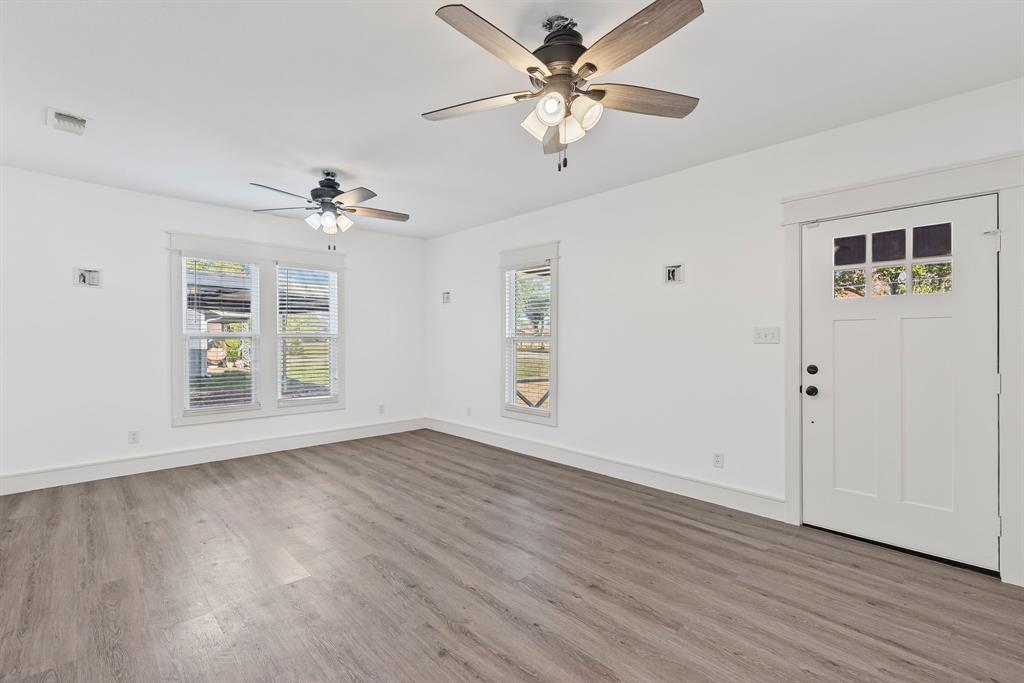 509 Maple Street Commerce, TX 75428 - Photo 8 of 36 a view of an empty room with a window and wooden floor
