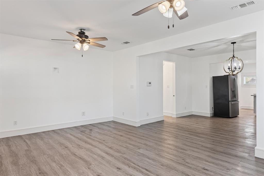 509 Maple Street Commerce, TX 75428 - Photo 9 of 36 a view of an empty room with wooden floor and a ceiling fan