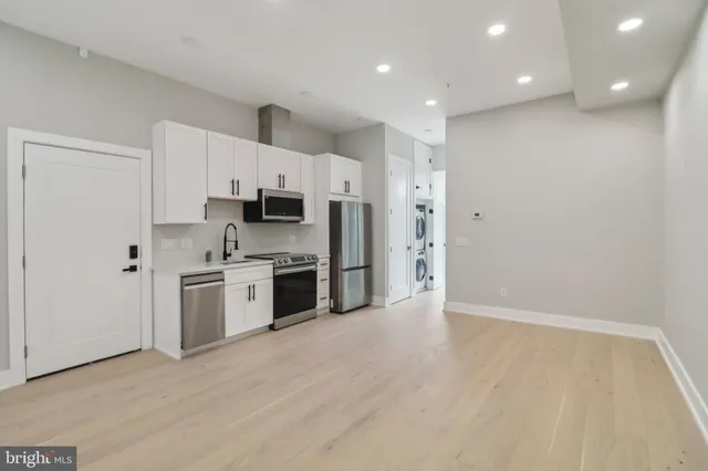 a kitchen with stainless steel appliances granite countertop a stove a sink and a refrigerator