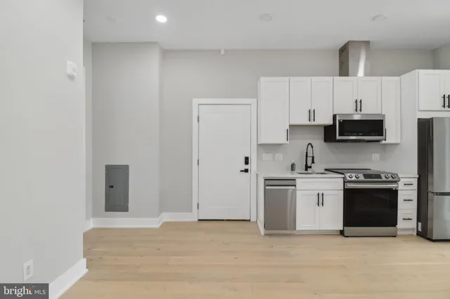 a kitchen with stainless steel appliances a refrigerator and a stove top oven
