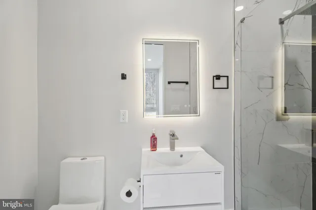 a bathroom with a toilet a sink and a mirror