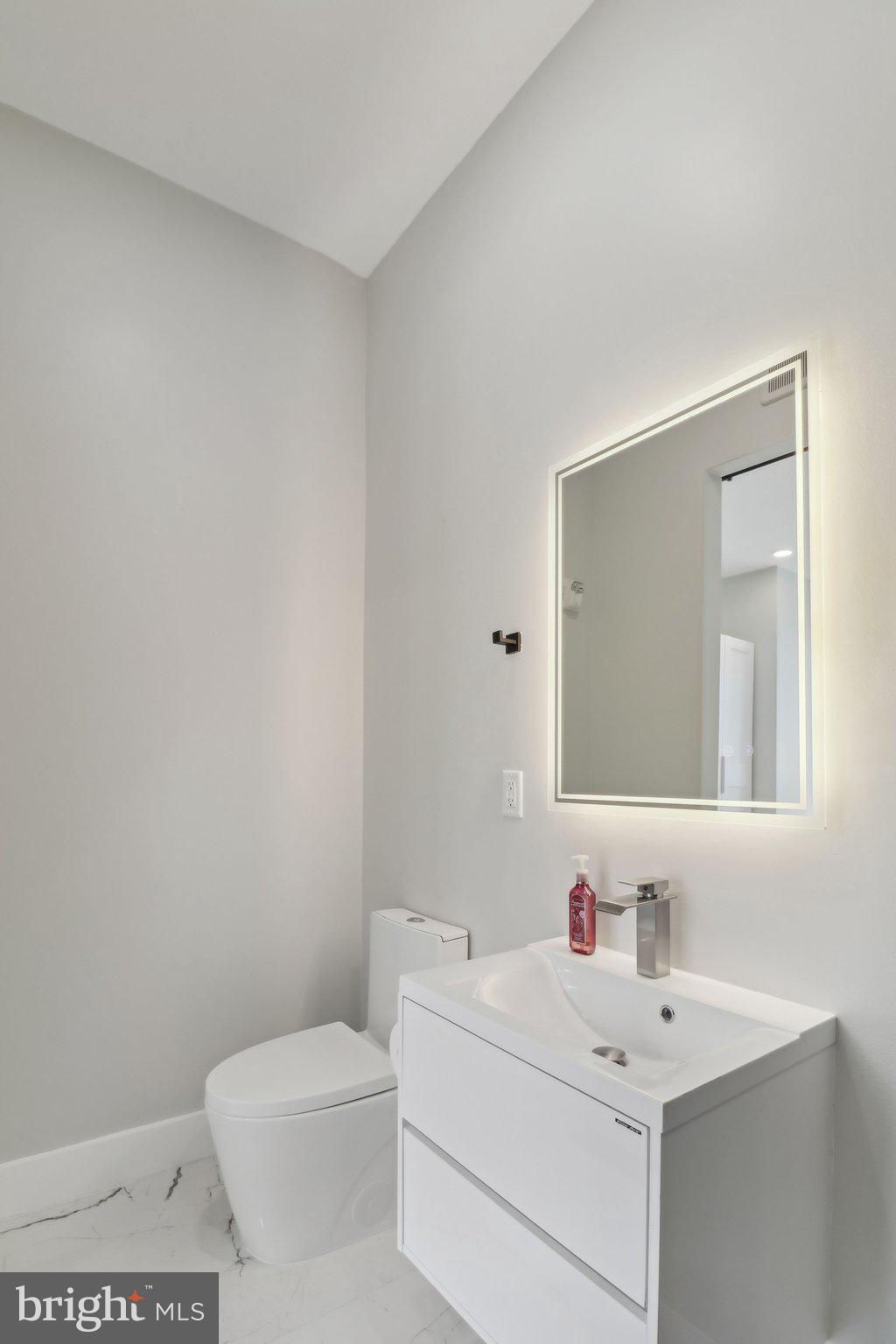 2213 M Street Northeast, Unit 4 Washington, DC 20002 - Photo 30 of 39 a bathroom with a toilet a sink and a mirror