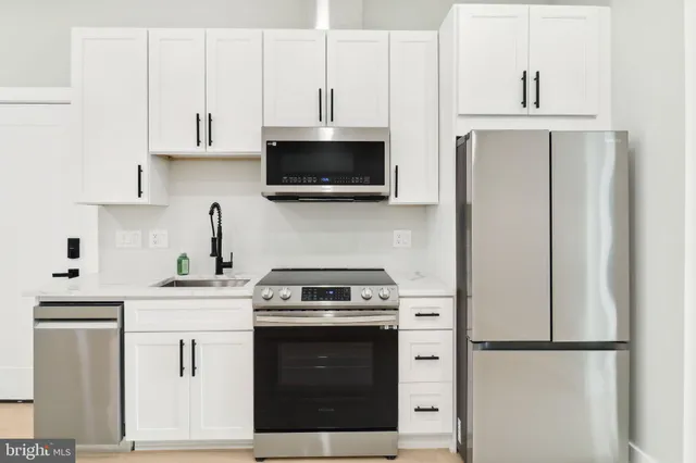 a kitchen with stainless steel appliances granite countertop a stove a sink and a refrigerator