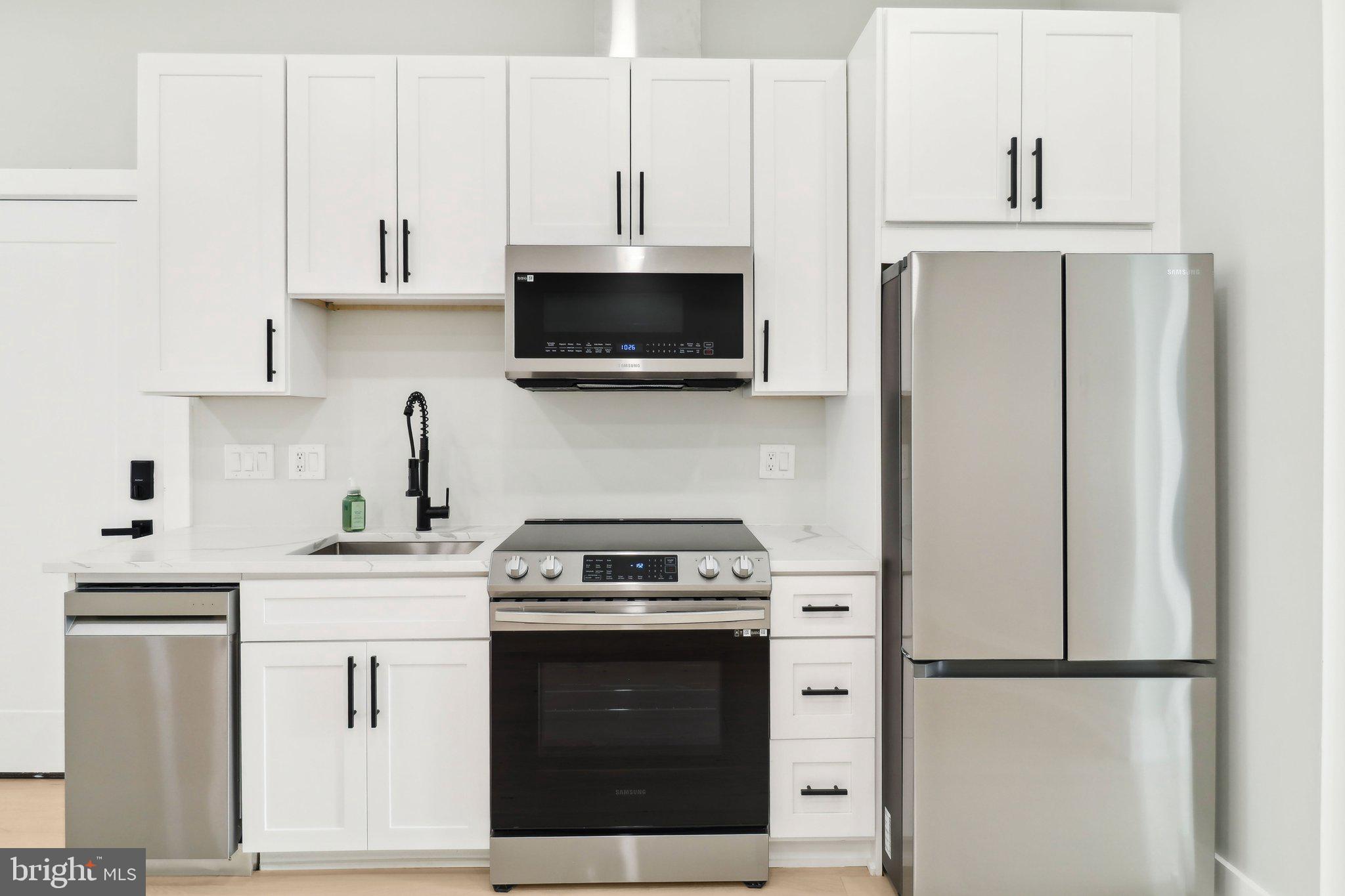 2213 M Street Northeast, Unit 4 Washington, DC 20002 - Photo 9 of 39 a kitchen with white cabinets and stainless steel appliances