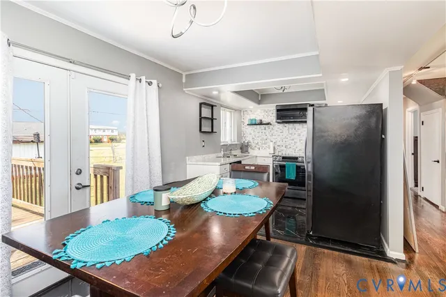 a kitchen with stainless steel appliances granite countertop a stove a refrigerator a dining table and chairs