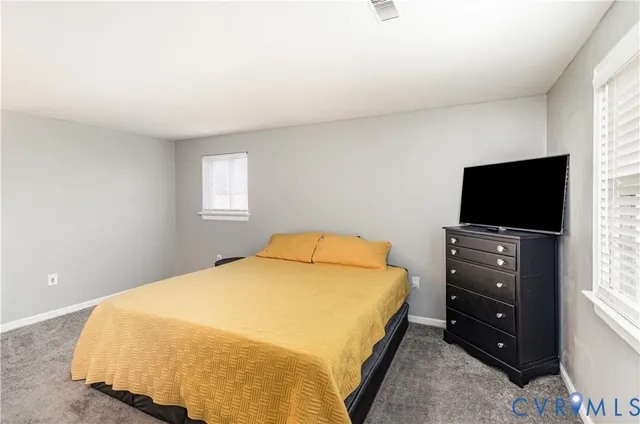 a bedroom with a bed and a flat tv screen on wall