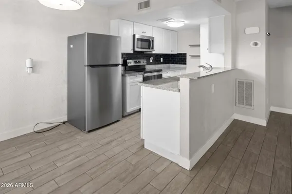 a kitchen with stainless steel appliances a refrigerator and a stove top oven