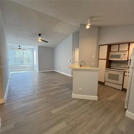 a view of a kitchen with wooden floor and electronic appliances