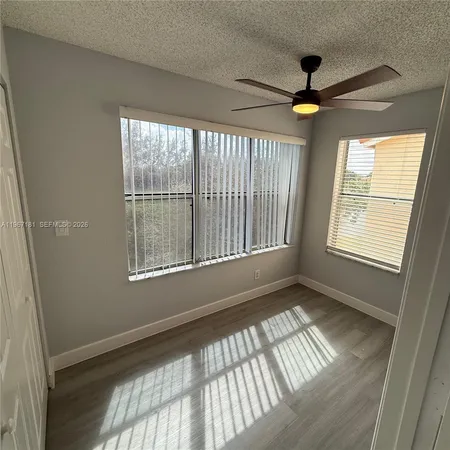 a view of an empty room and window chandelier fan