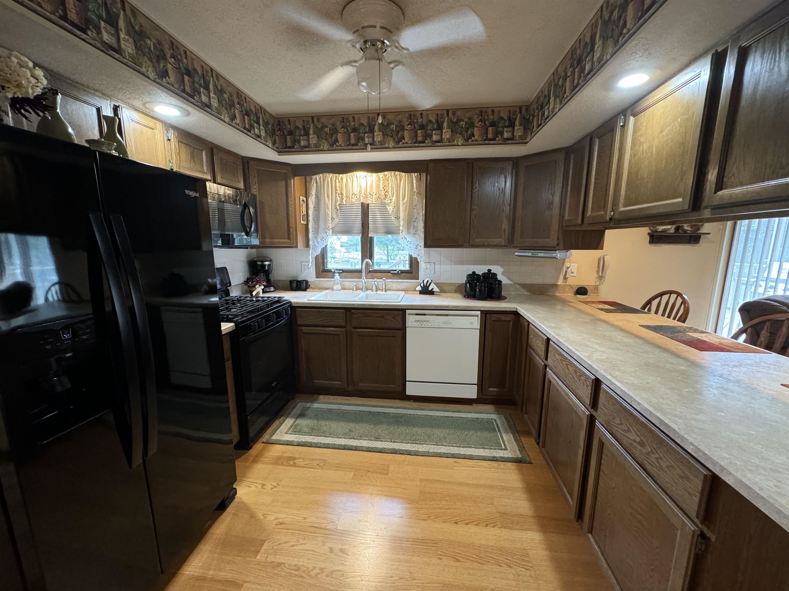 12255 Rae Ann Road Roscoe, IL 61073 - Photo 11 of 37 a kitchen with a sink stainless steel appliances a counter top space cabinets and a window