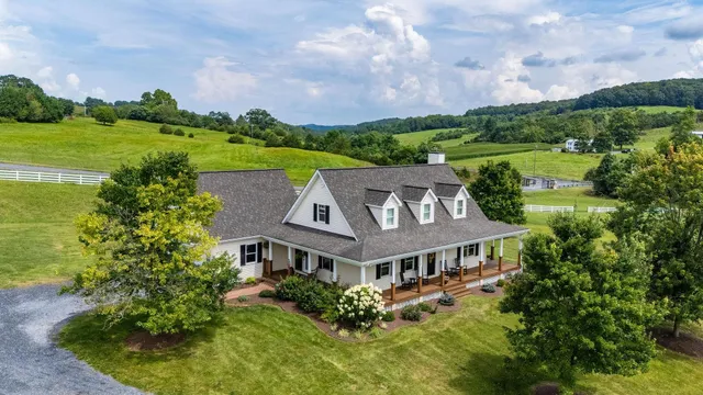 a front view of a house with swimming pool and chairs