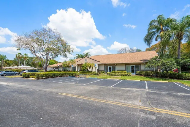 a view of a house with a big yard and large trees
